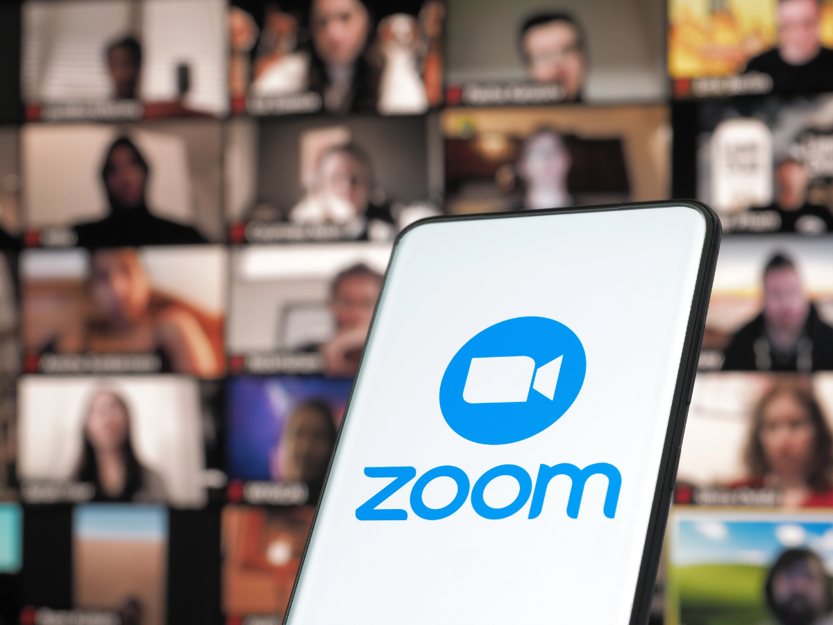 Smartphone showing the Zoom app with a live video training call grid in the background